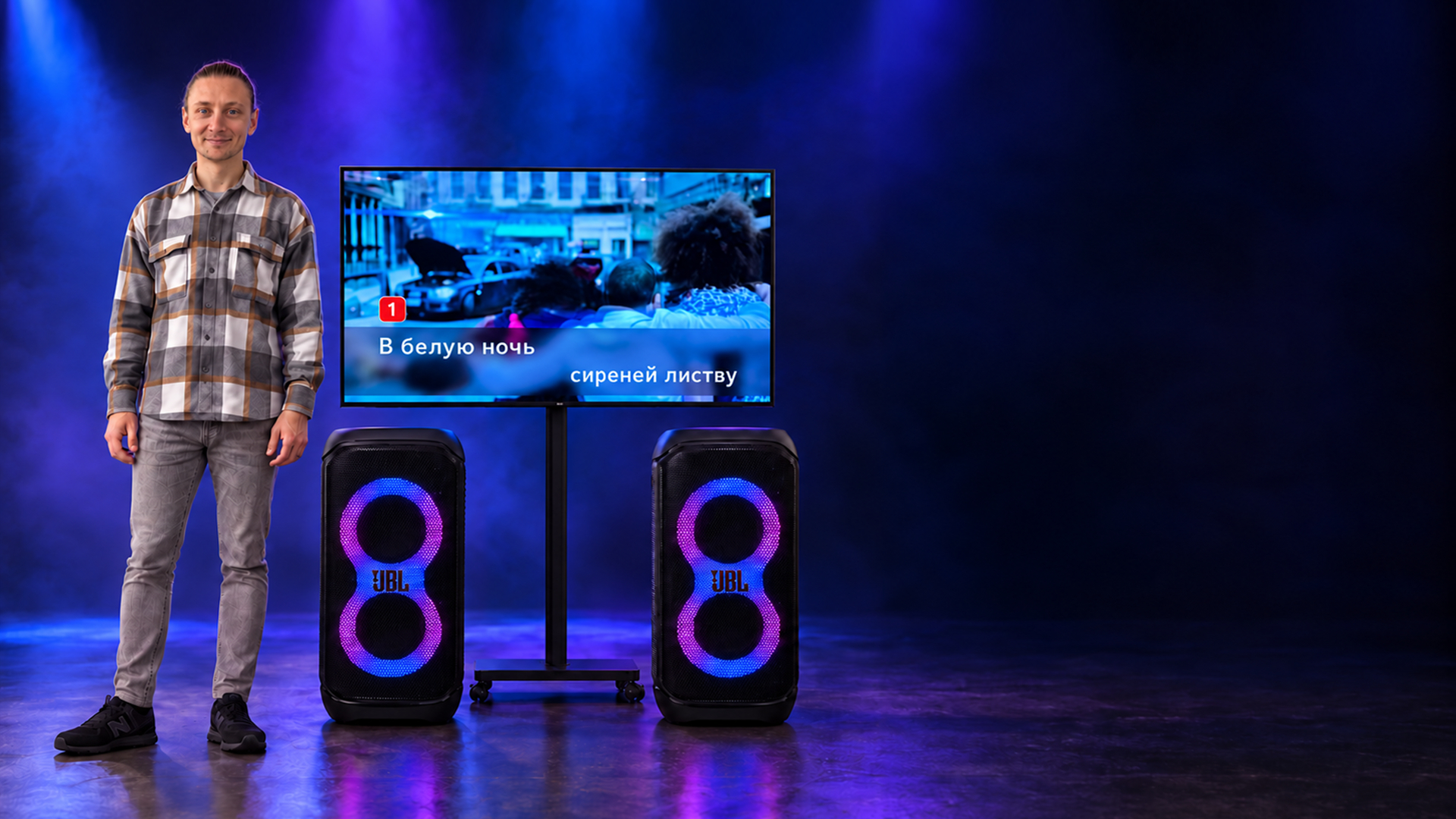 Телевизор на стойке и две колонки JBL